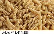 Gluten Free Cornmeal Pasta Wallpaper. Spiral Raw Macaroni from Corn and Rice flour rotating on Turntable. Close Up Top View. Uncooked Pasta Spinning. Full Frame. Food Background. Fusilli Bucati Corti. Стоковое видео, видеограф Марина Демидюк / Фотобанк Лори