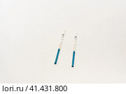 Положительный тест на беременность на белом фоне. Positive pregnancy test on a white background. Стоковое фото, фотограф Ольга Митряева / Фотобанк Лори