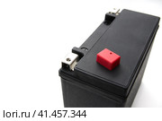 Photo of rechargeable starter lead-acid battery for motorcycle, jet ski or snowmobile. Positive terminal is shut with red cap. Isolated on white background. Space for logo. Фотография перезаряжаемой стартерной свинцово-кислотной батареи для мотоцикла, гидроцикла или снегохода. Положительная клемма закрыта красным колпачком. Изолированный на белом фоне. Место для логотипа. Стоковое фото, фотограф Дмитрий Березнев / Фотобанк Лори
