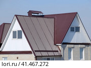 The house is with an attic and a combined roof. House with plastic windows and a brown roof of corrugated sheet. Стоковое фото, фотограф Леонид Еремейчук / Фотобанк Лори