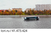 Речной электротрамвай плывет по Москве-реке. Современное электросудно движется вдоль реки. Московский городской транспорт (2023 год). Редакционное видео, видеограф Константин Григорьев / Фотобанк Лори