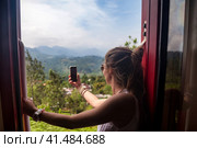 Lovely lady tourist travel by train to in Sri Lanka, takes selfie photo. Perfect traveler woman enjoying extreme sri lankan train ride in tropic. Tropical summer vacation concept. Copy ad text space (2022 год). Стоковое фото, фотограф Aleksandr Golubev / Фотобанк Лори