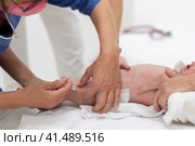 Baby beeing vaccinated by pediatrician in presence of his mother. Preventive vaccination against Diphtheria, whooping cough, tetanus, hepatitis, haemophilus influenzae, pneumococcus, poliomyelitis. Стоковое фото, фотограф Matej Kastelic / Фотобанк Лори