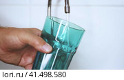 A jet of water flows into a glass. Drinking water from a tap. The man is fetching water. Стоковое видео, видеограф Алексей Круковский / Фотобанк Лори