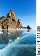 Beautiful winter landscape of frozen Baikal Lake on February. View from blue ice with cracks of famous rocks Big and Small Bell Towers (Kolokolny) - natural landmark and place of attraction for tourists. Стоковое фото, фотограф Виктория Катьянова / Фотобанк Лори