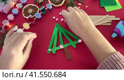 How to make christmas tree from ice cream sticks. Child decorates with pink balls New year handmade craft tree. Concept of DIY and kid's creativity. Стоковое видео, видеограф Ирина Старикова / Фотобанк Лори