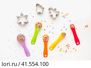 Мерные ложки на желтом фоне. Разноцветные пластиковые мерные ложки. Measuring spoons on a yellow background. Multi-colored plastic measuring spoons. Стоковое фото, фотограф Ольга Митряева / Фотобанк Лори