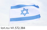 Big flag of Israel fastened on stick against background of blue sky under daylight. Стоковое видео, видеограф Яков Филимонов / Фотобанк Лори