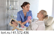 Old woman patient lying on clinical chair discussing face aesthetic procedures with doctor. Стоковое видео, видеограф Яков Филимонов / Фотобанк Лори