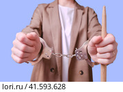 Restrained woman teacher handcuffed on a blue background, copy space. Стоковое фото, фотограф Андрей Журавлев / Фотобанк Лори