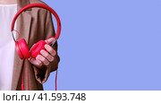 Woman teacher holding red headphones in her hands on a blue background, banner close-up. Стоковое фото, фотограф Андрей Журавлев / Фотобанк Лори