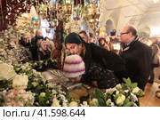 Ребёнок целует плащаницу в Новодевичьем монастыре в Страстную пятницу (2018 год). Редакционное фото, фотограф Дмитрий Неумоин / Фотобанк Лори