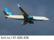Самолет Boeing 737-800 (RA-73225 ) авиакомпании "Победа" на глиссаде на фоне пасмурного неба (2023 год). Редакционное фото, фотограф Виктор Карасев / Фотобанк Лори