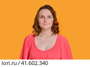Portrait of a smiling woman in a red dress on a yellow studio background. Стоковое фото, фотограф Андрей Журавлев / Фотобанк Лори
