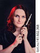 Portrait of a woman musician with a piccolo flute on a studio black background. Flutist with a small flute in her hands. Стоковое фото, фотограф Андрей Журавлев / Фотобанк Лори