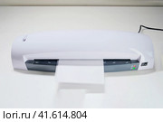 A machine for laminating photos and documents with plastic. Desktop white laminator, close-up. Стоковое фото, фотограф Андрей Журавлев / Фотобанк Лори