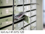 Mailboxes in the condominium are littered with correspondence, overflowing. Paper letters lie in an open mailbox, filled with spam. Стоковое фото, фотограф Андрей Журавлев / Фотобанк Лори