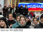 Молодые люди, члены Движение первых поют национальный гимн России во время репетиции музыкального спектакля "1000 первых", который должен состояться в День народного единства во время проведения выставки-форума Россия на ВДНХ в городе Москве, Россия (2023 год). Редакционное фото, фотограф Николай Винокуров / Фотобанк Лори