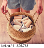 Woman holds empty rolls of empty toilet paper in basket. Concept of bowel disease, food poisoning and diarrhea. Стоковое фото, фотограф Андрей Журавлев / Фотобанк Лори