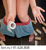 Woman hand with leftover toilet paper and empty rolls on the floor. Problems with toilet paper in the shops because of the quarantine. Стоковое фото, фотограф Андрей Журавлев / Фотобанк Лори