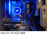 Open pc system unit with ice blue light liquid cooling - Moscow, Russia, December 23, 2020. Редакционное фото, фотограф Андрей Журавлев / Фотобанк Лори