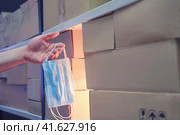 Male hand in a warehouse with medical masks near the boxes. Стоковое фото, фотограф Андрей Журавлев / Фотобанк Лори