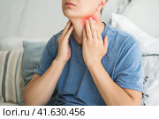 Sore throat and cough, man with pain in neck at home. Стоковое фото, фотограф Станислав Тарко / Фотобанк Лори