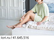 Woman makes a lymphatic drainage massage of the legs with a dry brush, body care concept. Стоковое фото, фотограф Станислав Тарко / Фотобанк Лори