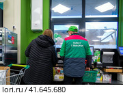 Консультант помогает покупателю в магазине "Вкусвилл" (2023 год). Редакционное фото, фотограф Вячеслав Палес / Фотобанк Лори