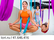 Young woman performing antigravity yoga exercise in gym. Стоковое фото, фотограф Яков Филимонов / Фотобанк Лори