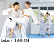 Young female karateka honing knee strike technique during kumite. Стоковое фото, фотограф Яков Филимонов / Фотобанк Лори