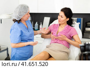 Woman consulting with cosmetologist about breast augmentation procedures. Стоковое фото, фотограф Яков Филимонов / Фотобанк Лори