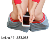 Female legs on the background of the remnants of toilet paper and a phone in her hands, isolated on a white background. Concept stomach disease, poisoning and diarrhea problems. Стоковое фото, фотограф Андрей Журавлев / Фотобанк Лори