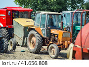 Tractor, standing in a row. Agricultural machinery. (2015 год). Редакционное фото, фотограф Леонид Еремейчук / Фотобанк Лори