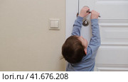 Little baby opens the door. Child pulls the door handle with the lock closed. Kid aged about two years (one year nine months) Стоковое видео, видеограф Андрей Журавлев / Фотобанк Лори