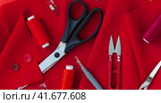 Video of sewing supplies lie on beautiful red suit fabric. Concept of sewing festive elegant clothes. Blank space for text advertising sew workshop, atelier or handicraft school. Top view, flat lay, close-up. Стоковое видео, видеограф Виктория Катьянова / Фотобанк Лори