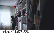 The mother is a housewife looking for clothes in the closet. Стоковое фото, фотограф Mikhail Davidovich / Фотобанк Лори