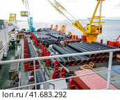 The deck lay barge. Pipes and Lifting cranes on the ship. Equipment for laying a pipeline on the seabed. Стоковое фото, фотограф Леонид Еремейчук / Фотобанк Лори