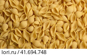 Conchiglie, Shells or Seashells Pasta Wallpaper. Spiral Raw Macaroni from Wheat flour rotating on Turntable. Close Up Top View. Uncooked Pasta Spinning. Full Frame. Food Background. Conchigliette. Стоковое видео, видеограф Марина Демидюк / Фотобанк Лори