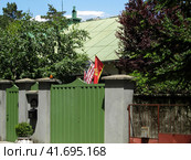 Cetinje, Montenegro - June 24, 2019. US and Montenegro flags on a residential house in Vojvode Boza street. Флаги США и Черногории на жилом доме в Цетине, Черногория. Стоковое фото, фотограф Александр Кузнецов / Фотобанк Лори