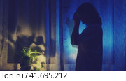 Woman crying at night dark window, low key silhouette. The shadow of a sad female against the background of a window curtain, stop motion. Стоковое видео, видеограф Андрей Журавлев / Фотобанк Лори