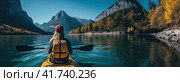 A girl on a yellow canoe is sailing on a mountain lake in calm weather. T Generated by AI. Стоковое AI-изображение, AI-художник Ярославский Максим / Фотобанк Лори