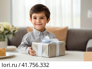 Childs face lights up with joy as they unwrap a birthday gift, revealing a thoughtful surprise. Стоковое AI-изображение, AI-художник Юрий Поздников / Фотобанк Лори