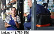 Mature man drive operate automatic fork lift loader and answers young female auditors questions. Стоковое видео, видеограф Яков Филимонов / Фотобанк Лори