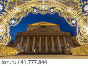 Большой театр, Москва, Россия. Вид на Театральную площадь и здание Большого театра. Вечерний городской пейзаж. Красивое новогоднее украшение города. Арка из светящихся гирлянд. Праздничное настроение. Туристическая достопримечательность. Редакционное фото, фотограф Андрей Степанов / Фотобанк Лори