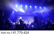Symphony orchestra concert in mysterious darkness under stage spotlights. The conductor controls the orchestra. Редакционное видео, видеограф Евгений Ткачёв / Фотобанк Лори