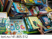 Прилавок с детскими книгами на английском языке на международной ярмарке интеллектуальной литературы Non/fiction в Гостином дворе города Москвы, Россия (2023 год). Редакционное фото, фотограф Николай Винокуров / Фотобанк Лори