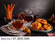 Carrot cookies with walnuts and tea in a cup against a dark background. Стоковое фото, фотограф Ирина Толокновская / Фотобанк Лори