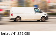 Fast moving Volkswagen Transporter T6.1 on the city road. White minivan rides on street. Commercial auto in fast motion with blurred background. speeding in the city concept. Редакционное фото, фотограф Константин Григорьев / Фотобанк Лори