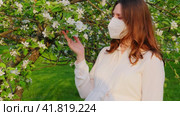 Pregnant woman in medical face mask n95 with apple tree flowers in spring nature. Happiness of pregnancy during covid epidemic, coronavirus pandemic quarantine. Стоковое видео, видеограф Андрей Журавлев / Фотобанк Лори